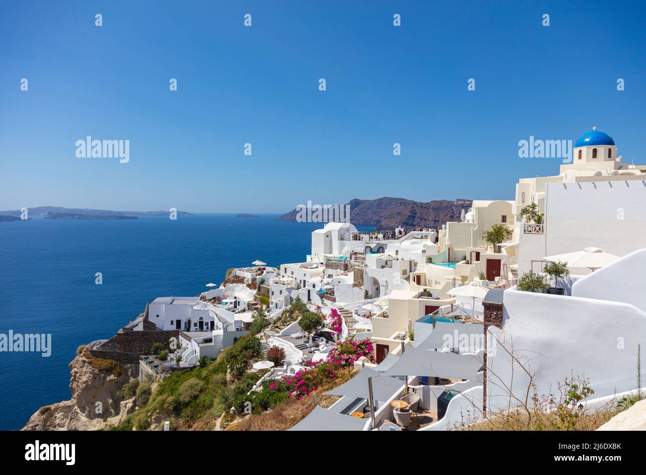 Santorini, Greece - August 7, 2021: View over the roofs of the typical houses of Santorini, island in the cyclades archipelago in the Aegean Sea. Whit Stock Photo