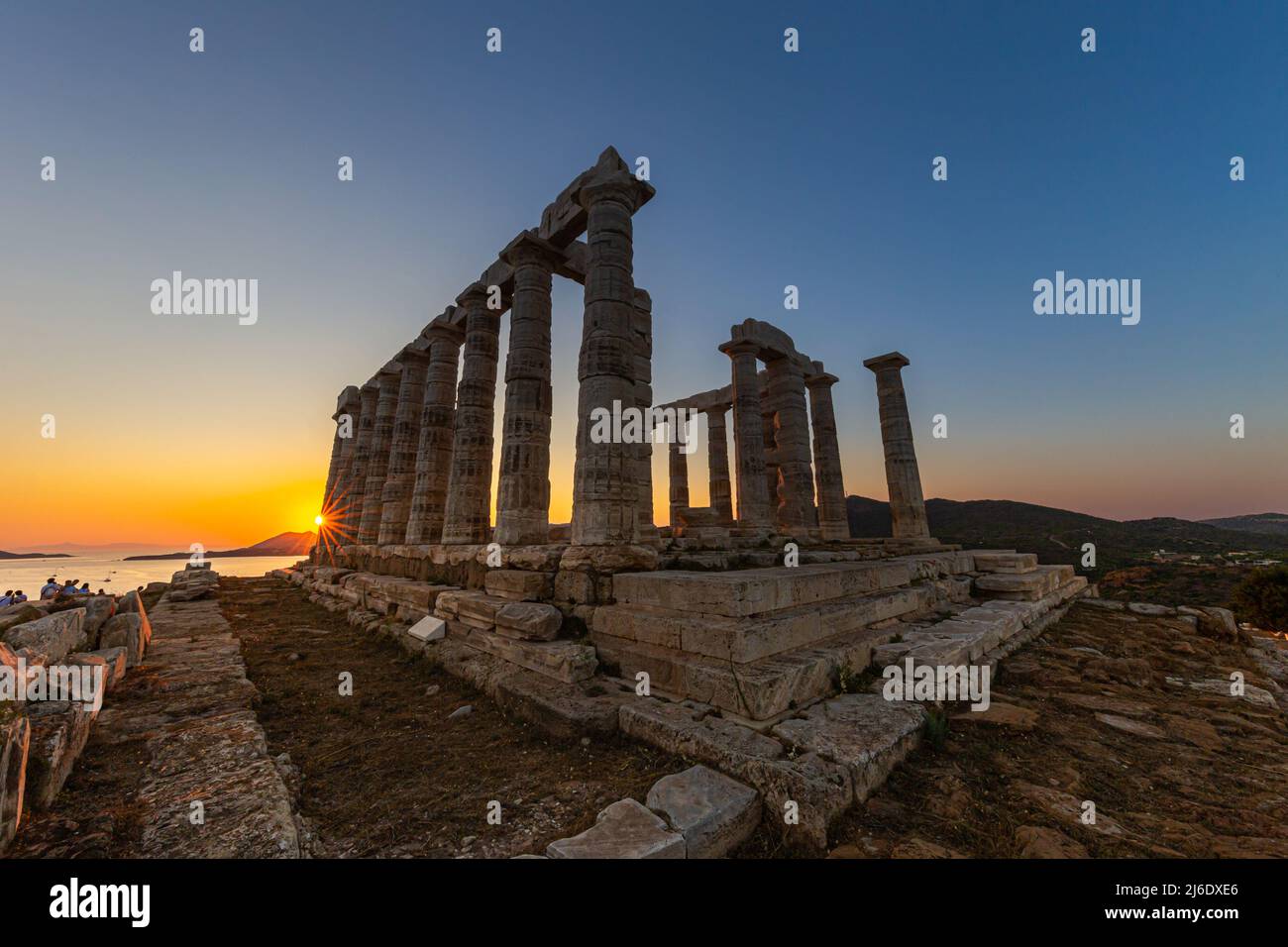 Amazing colorful sunset at the Temple of Poseidon, archaeological site of Sounion, Attica. Cape Sounion, Lavrio, Greece. A sunset behind the citadel o Stock Photo