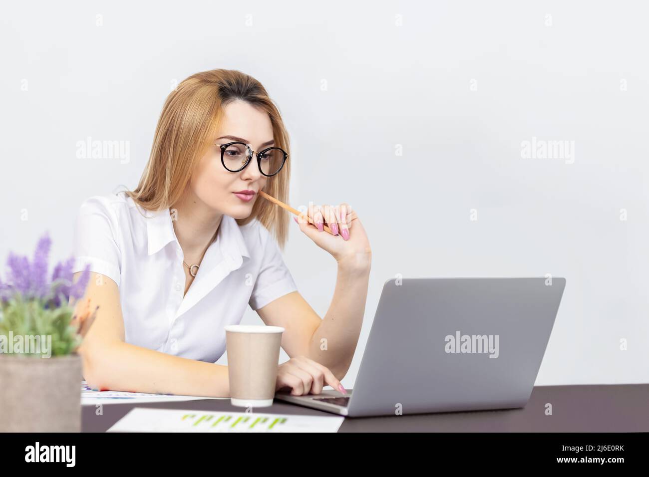 Portrait of blond woman working on laptop from office Stock Photo