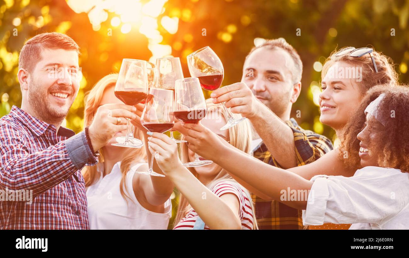 Trendy friends drinking and toasting red wine at restaurant party Stock Photo