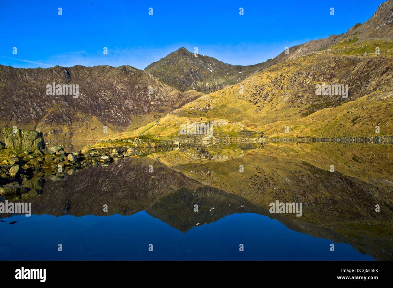 Ruins of the old crushing mill reflected in Llyn Llydaw on the Miner's Track at Mt Snowdon, Wales, UK Stock Photo