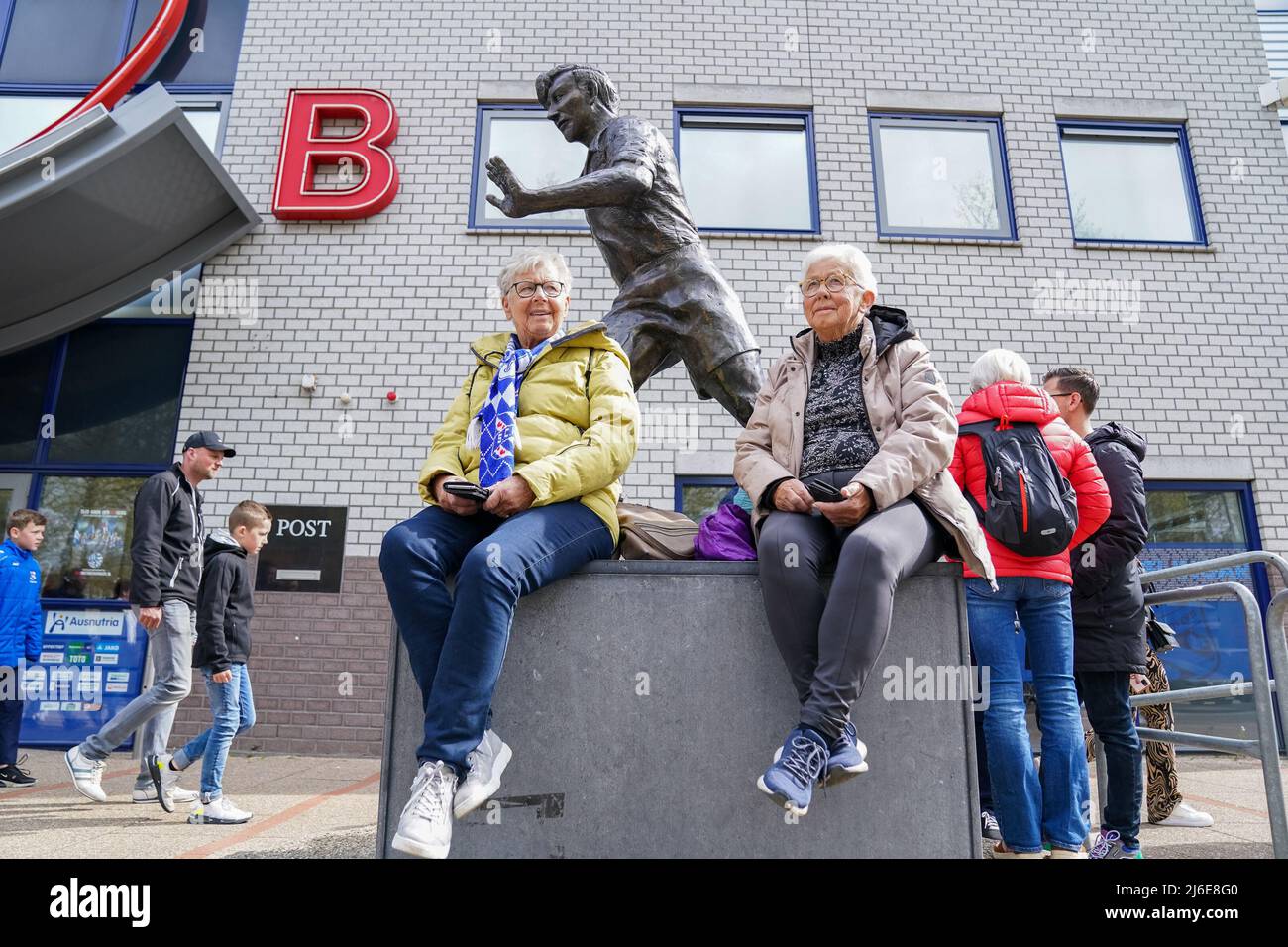 HEERENVEEN, NETHERLANDS - MAY 1: Two supporters sit besides the statue of Abe Lenstra in front of the stadium prior to the Dutch Eredivisie match between sc Heerenveen and SC Cambuur at the Abe Lenstra Stadion on May 1, 2022 in Heerenveen, Netherlands (Photo by Rene Nijhuis/Orange Pictures) Stock Photo