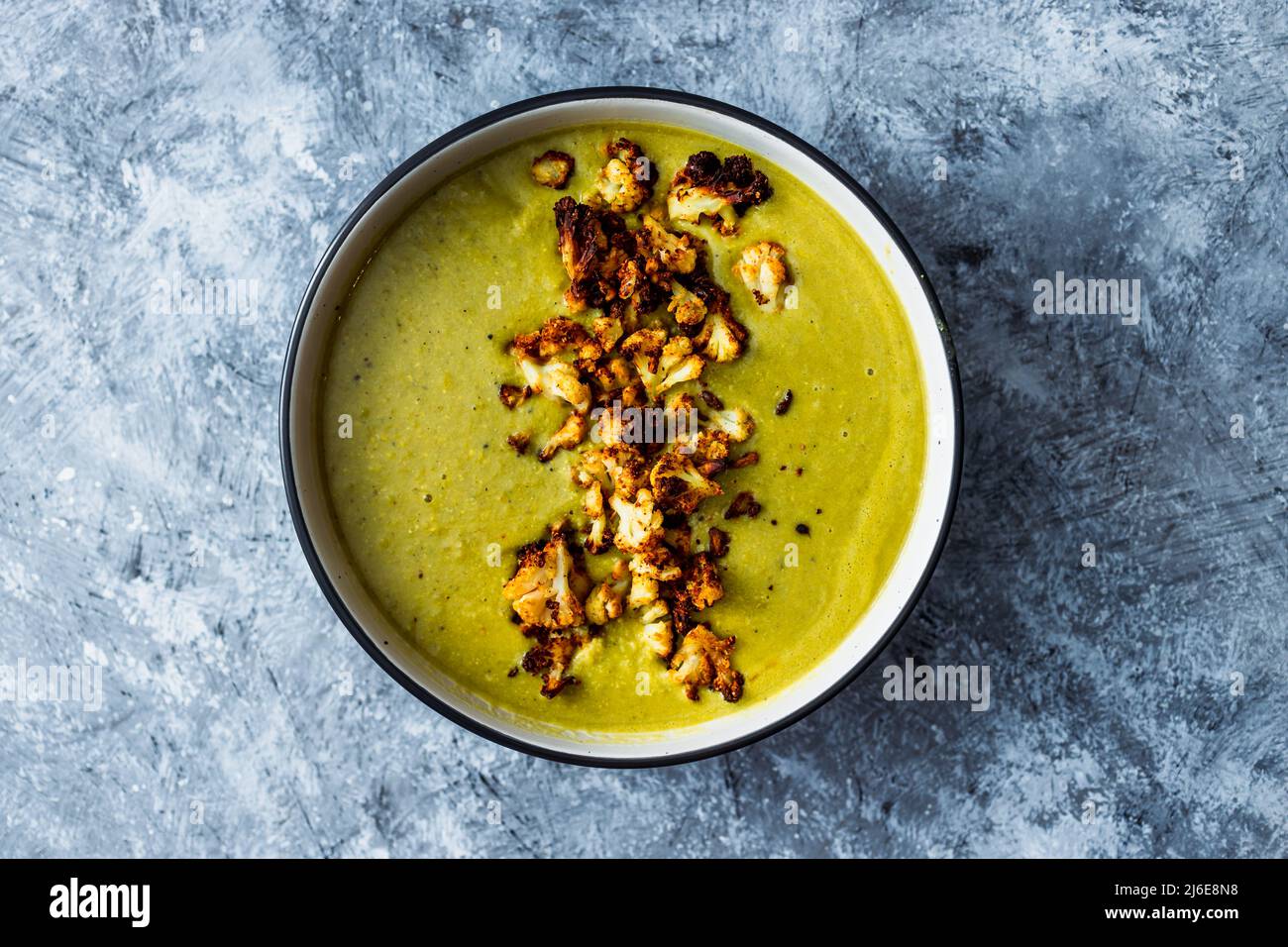 vegan homemade creamy broccoli soup with roasted cauliflower topping