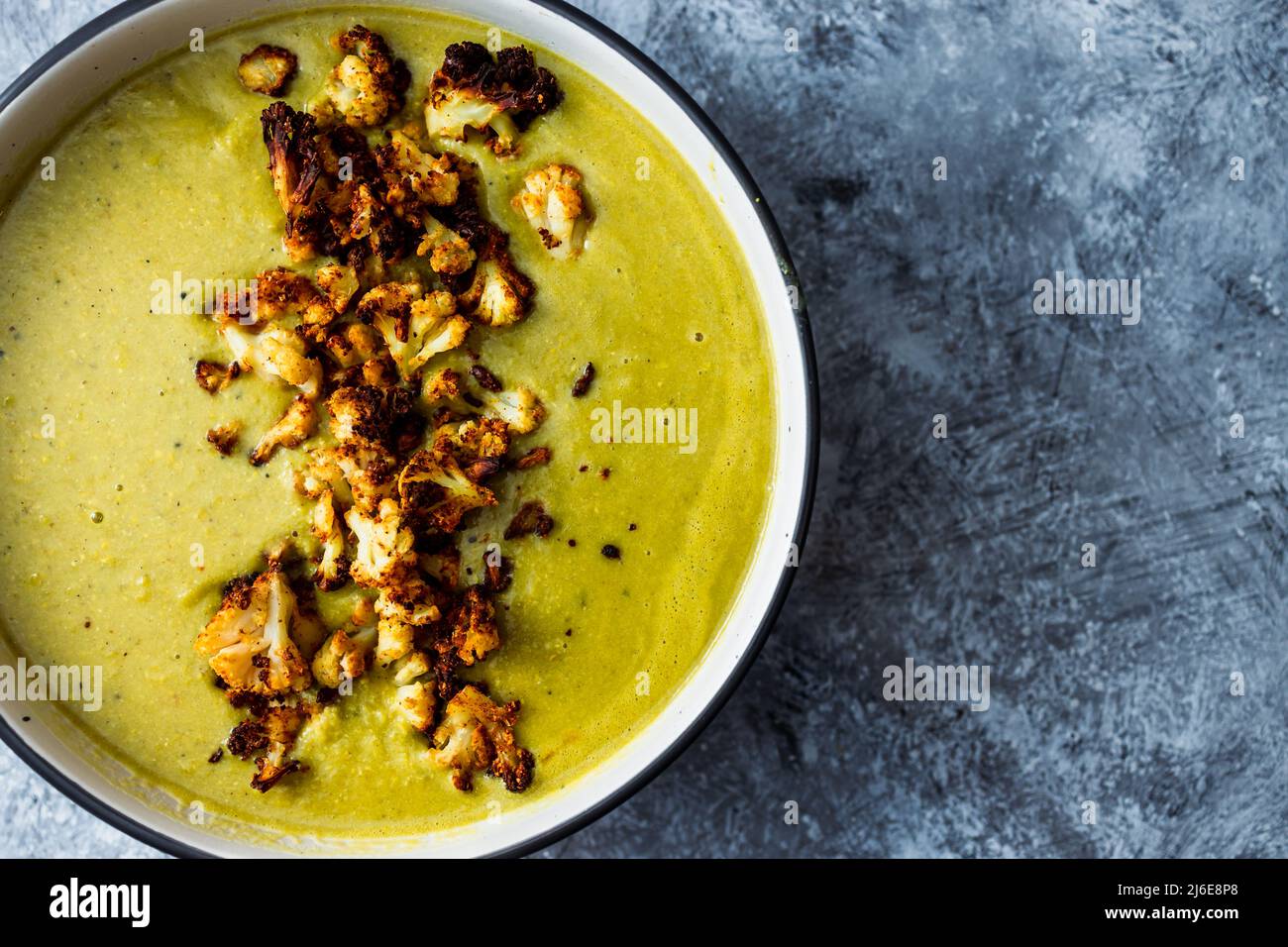 vegan homemade creamy broccoli soup with roasted cauliflower topping