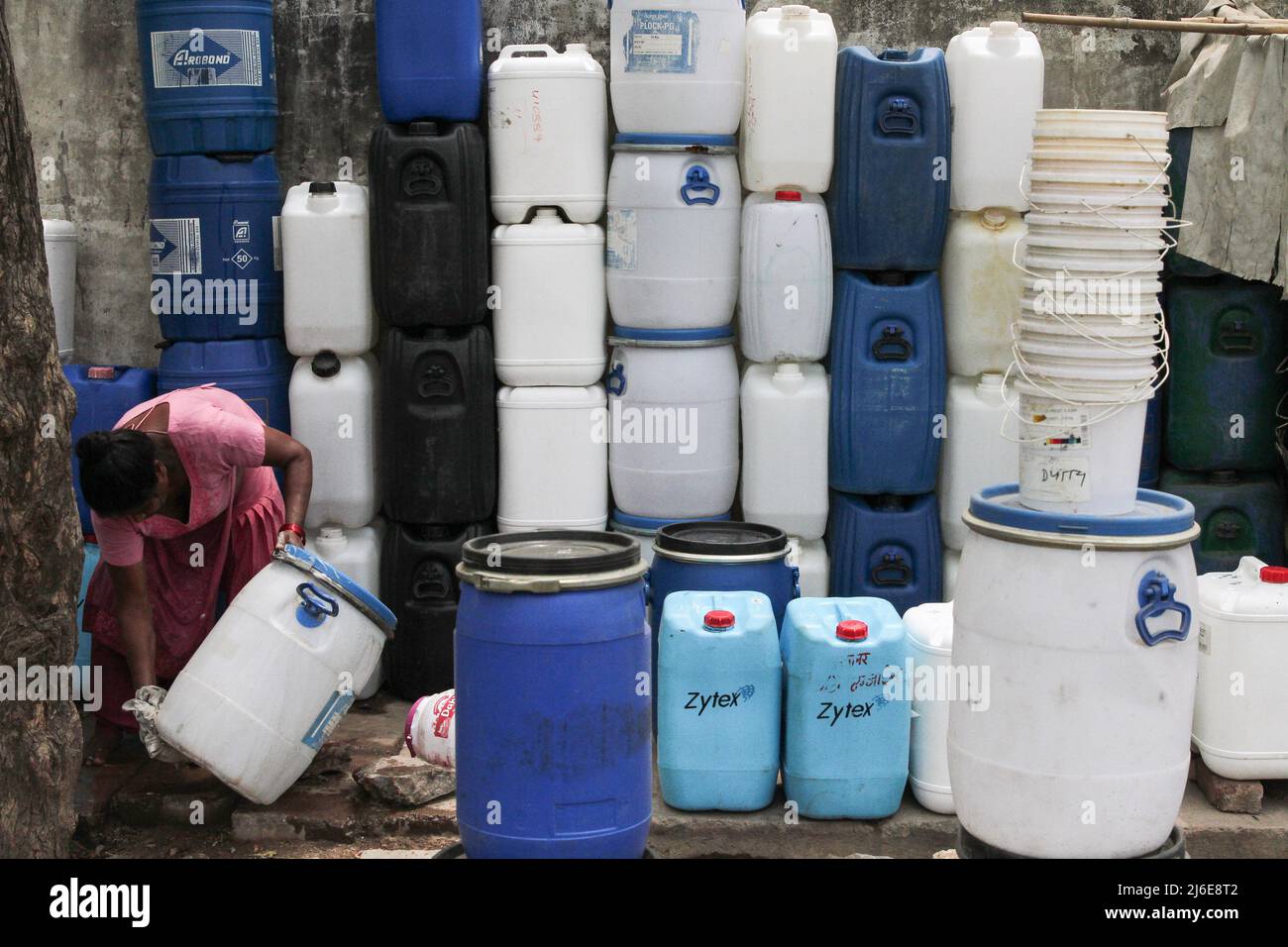 May 1, 2022, New Delhi, New Delhi, India: A woman cleans a plastic container kept for sale on a street on a hot summer day. (Credit Image: ©  Karma Sonam Bhutia/ZUMA Press Wire) Stock Photo