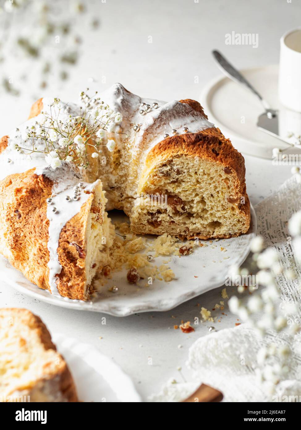 Bundt cake decorated with icing sprinkles and flowers. High key with a frame of flowers in blur Stock Photo