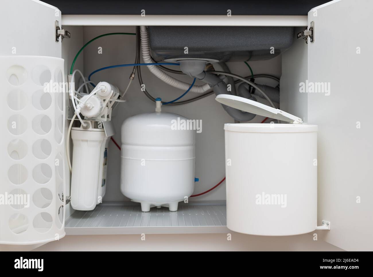 Opened kitchen with sink, garbage bin, water filtration system