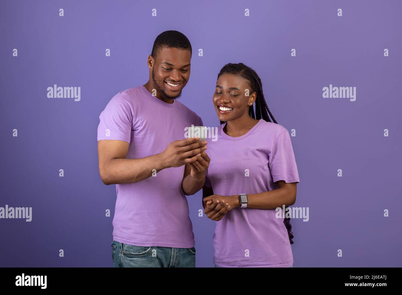Portrait of smiling black couple using smartphone Stock Photo