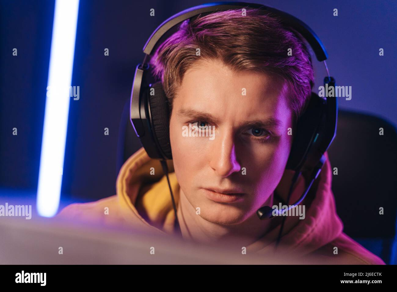 Guy cyber sportsman streaming while playing shooting game Stock Photo