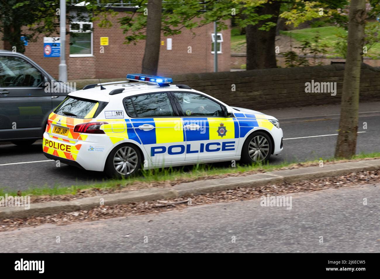 West Yorkshire police car on Harehills Lane, Chapel Allerton, responding to an emergency with blue lights flashing, Leeds, England, UK Stock Photo