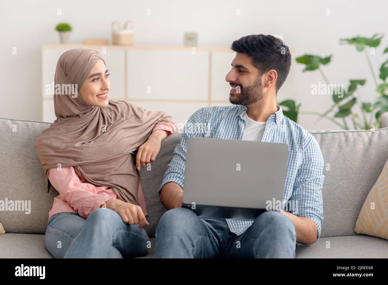 Happy Islamic Spouses Using Laptop Computer Together At Home Stock Photo