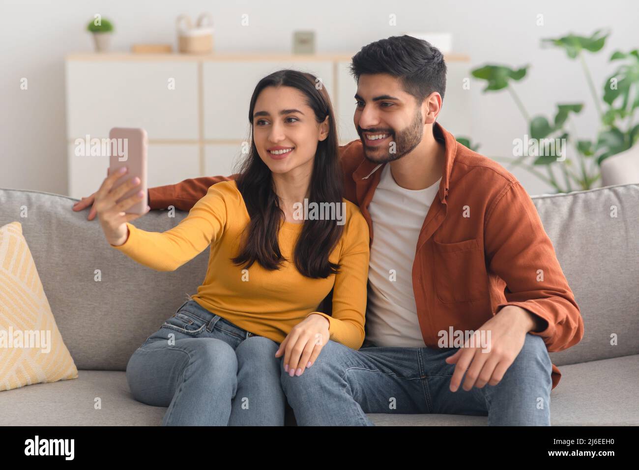 Happy Arabic Spouses Making Selfie Using Mobile Phone Indoor Stock Photo