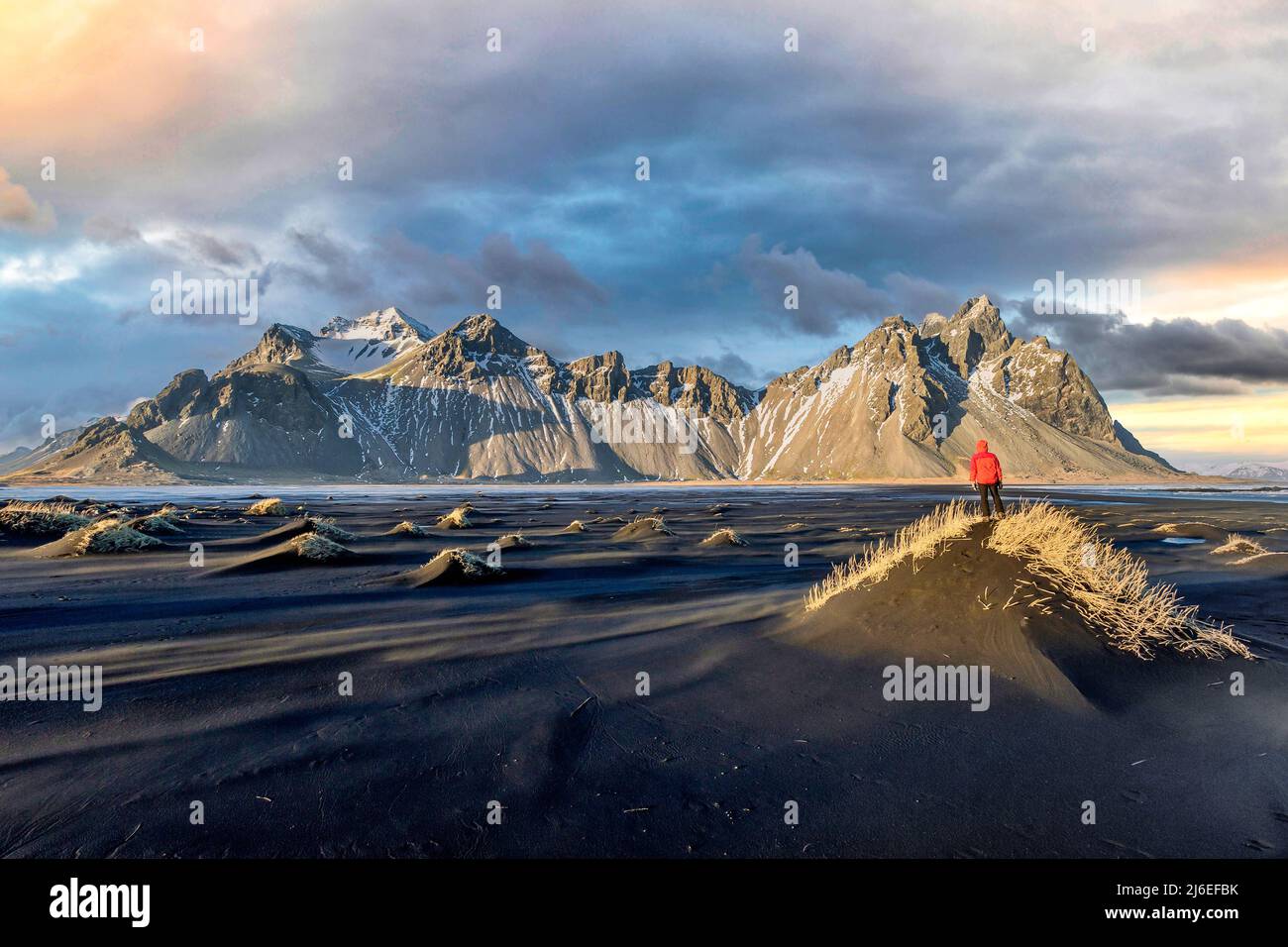 Hiker enjoying sunset at Vestrahorn and its black sand beach in Iceland Stock Photo