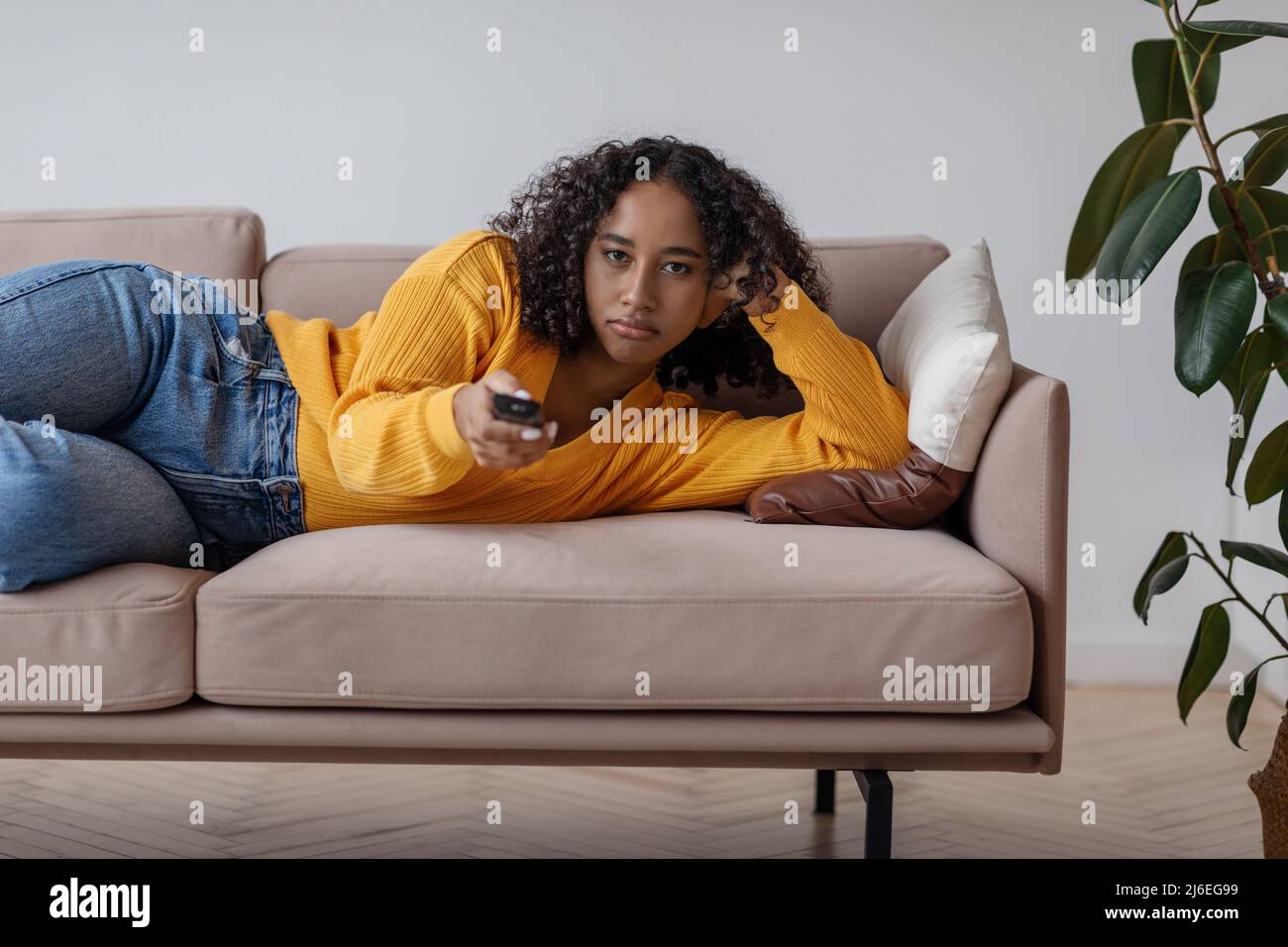 Woman lying on sofa watching tv hi-res stock photography and images - Alamy