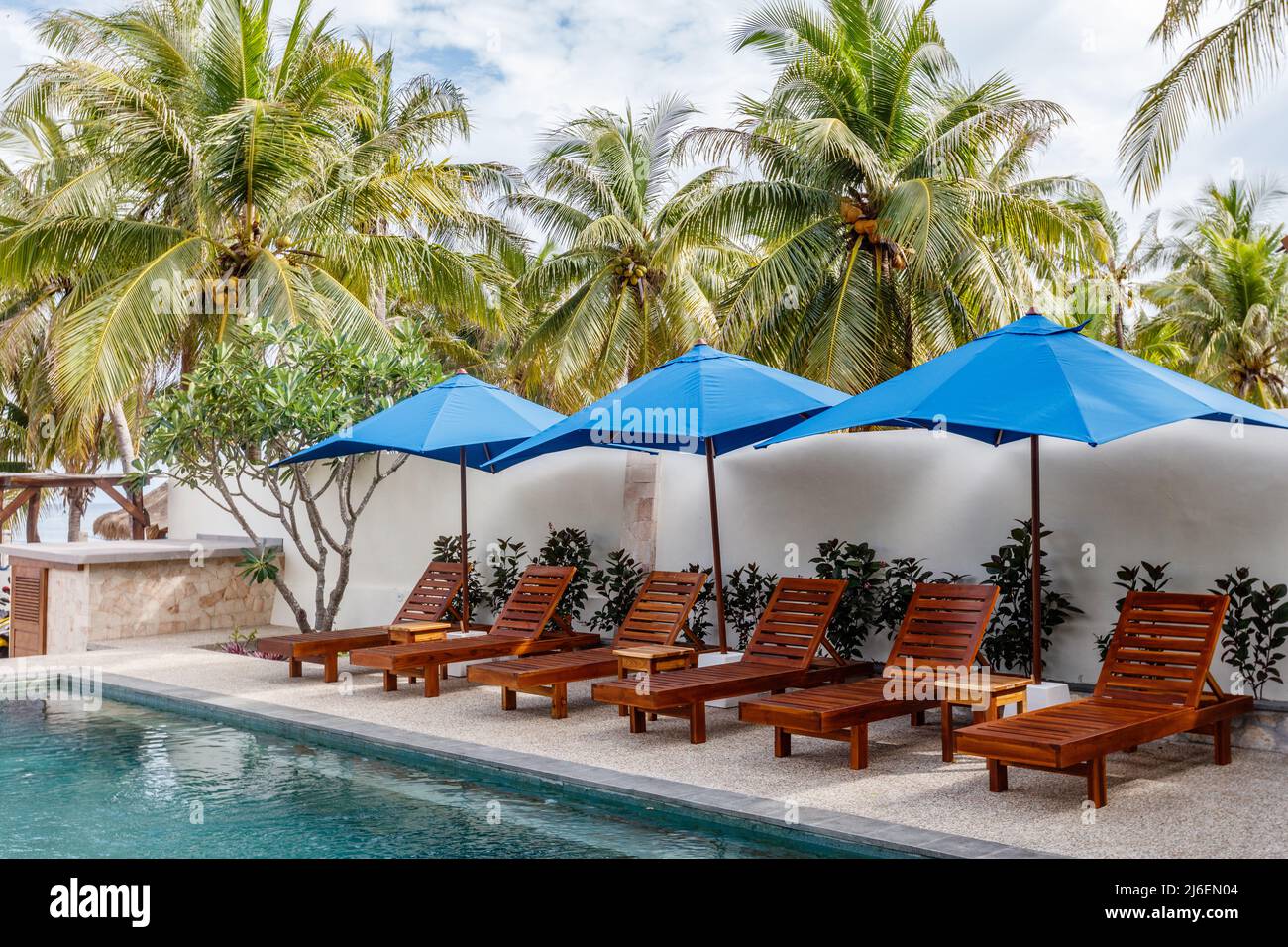 Sun loungers and umbrellas near the swimming pool. Destination holiday. Indonesia. Stock Photo