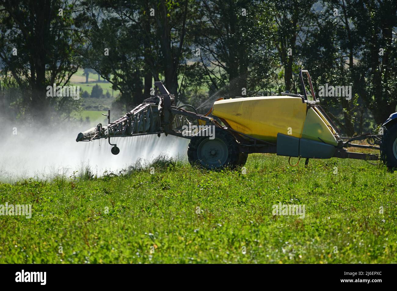 A farmer uses a large sprayer to spread herbicide on a paddock Stock Photo