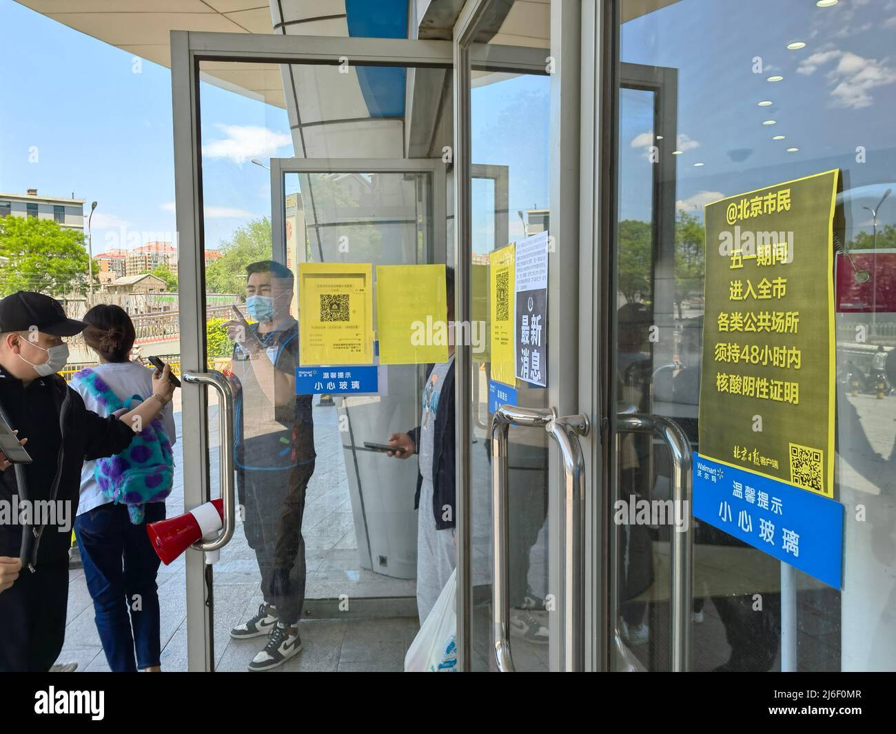 (220501) -- BEIJING, May 1, 2022 (Xinhua) -- A staff member checks consumers' negative results of nucleic acid tests taken within 48 hours at the entrance of a supermarket in Beijing, capital of China, May 1, 2022. (Xinhua/Li Xin) Stock Photo