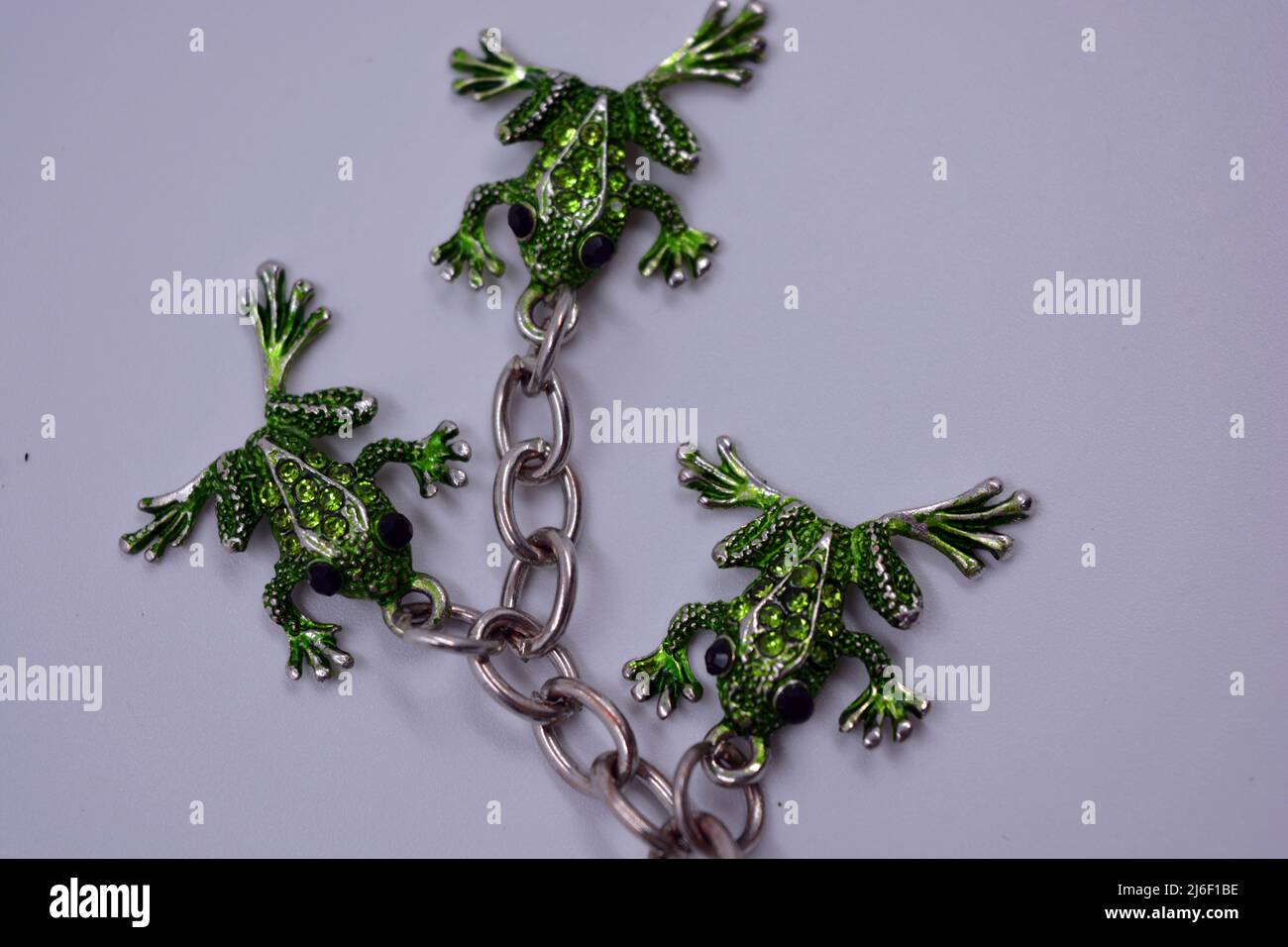 A beautiful, bright keychain decorated with small green frogs, toads