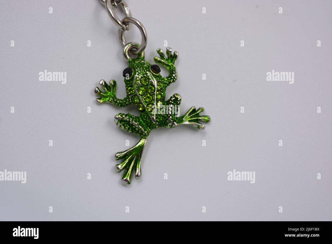 https://c8.alamy.com/comp/2J6F1BX/a-beautiful-bright-keychain-decorated-with-small-green-frogs-toads-with-small-green-stones-jewelry-from-a-metal-chain-of-three-small-frogs-decorat-2J6F1BX.jpg