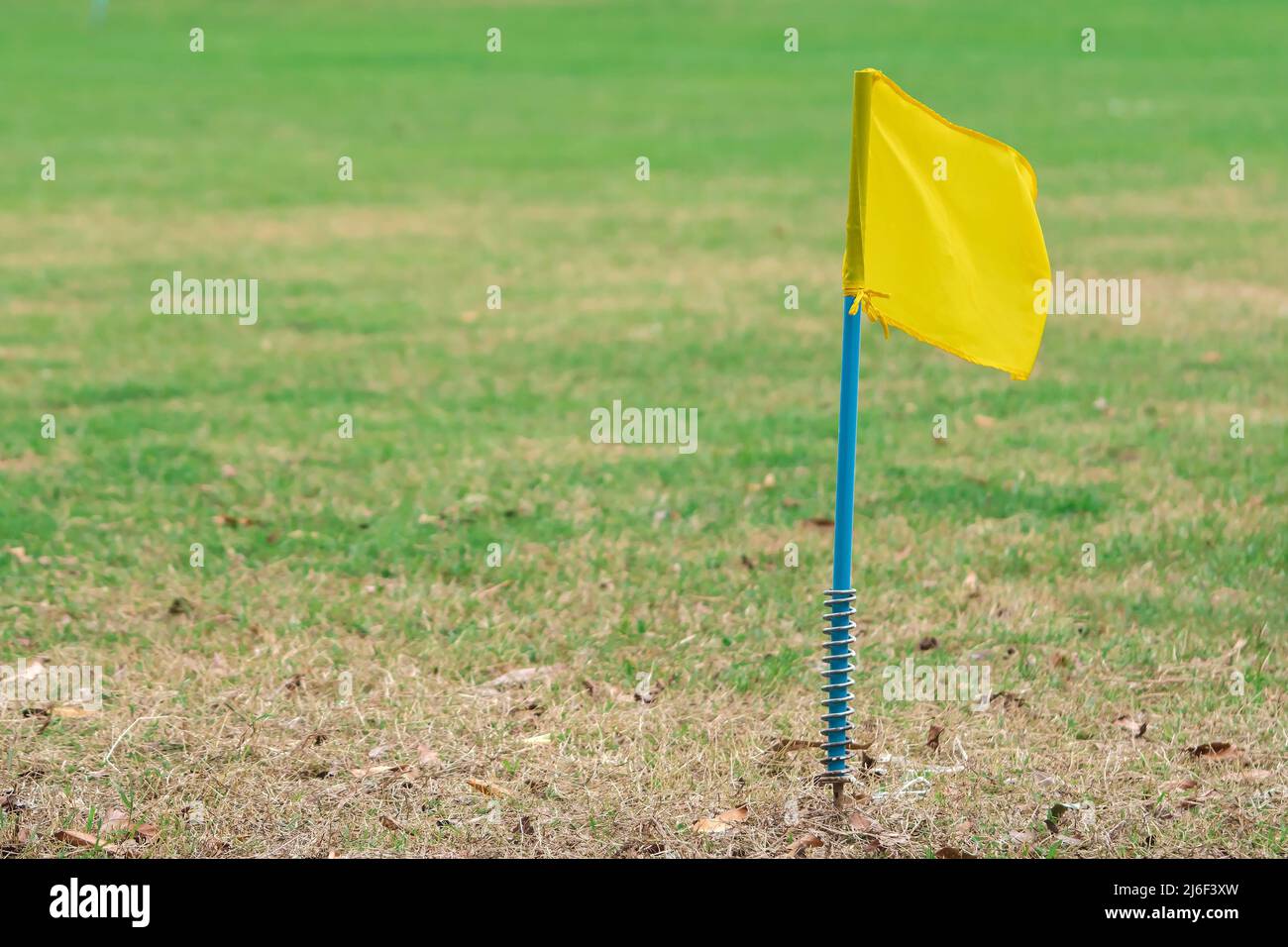 A simple yellow flag on the corner of football field in school. Place