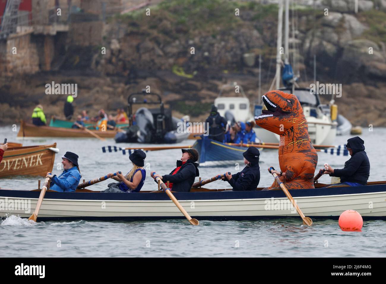 A rower wearing a dinosaur costume takes part in the World Pilot Gig rowing Championships, in the Isles of Scilly, Britain, May 1, 2022. REUTERS/Tom Nicholson Stock Photo