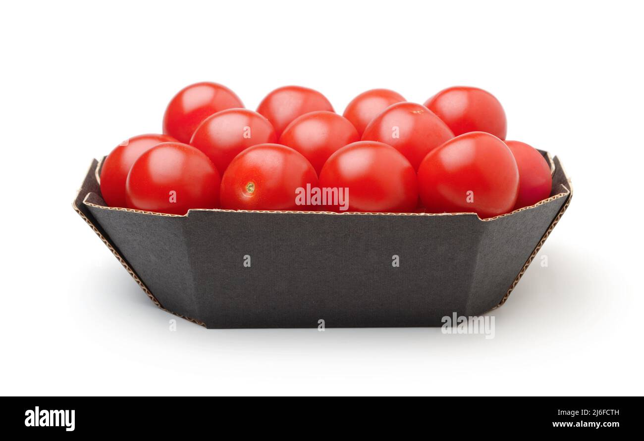 Ripe cherry tomatoes in a cardboard box isolated on white. Stock Photo