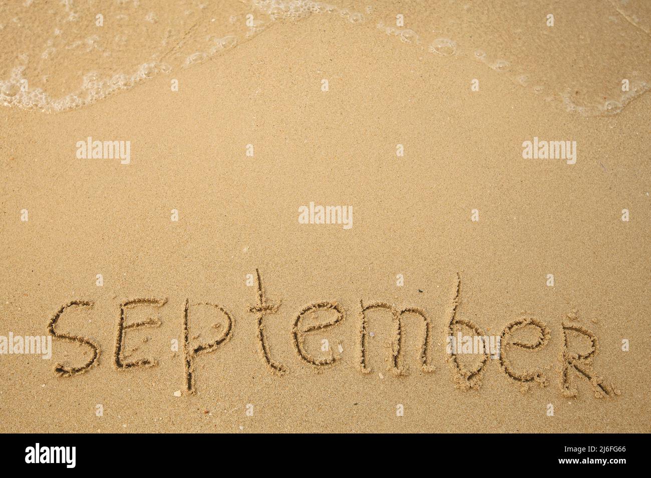 September - handwritten on the soft beach sand Stock Photo - Alamy