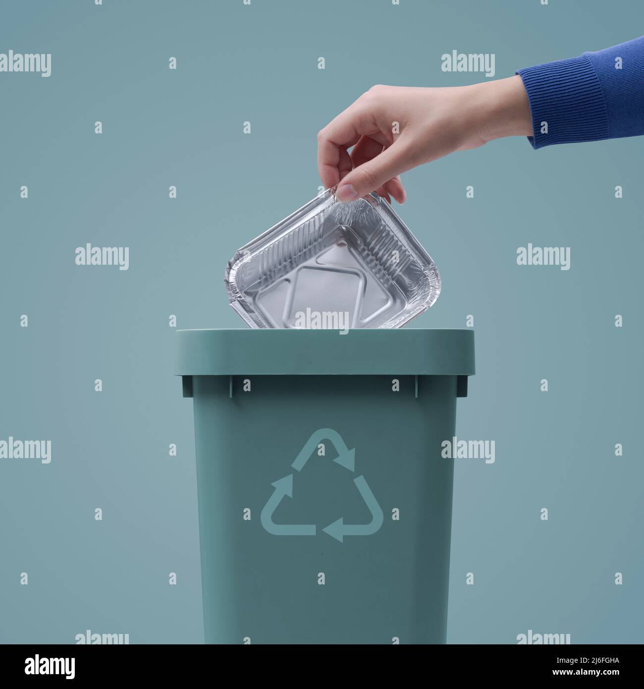 Woman putting an aluminum foil pan in the trash bin, recycling concept Stock Photo Alamy