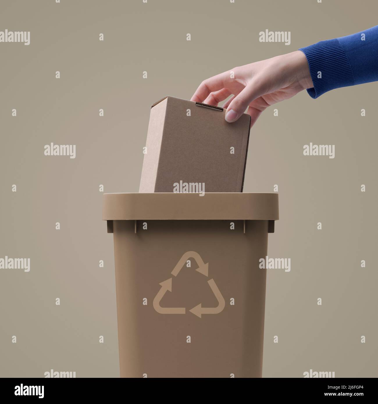 Woman putting a cardboard box package in the trash bin, separate waste collection and recycling concept Stock Photo