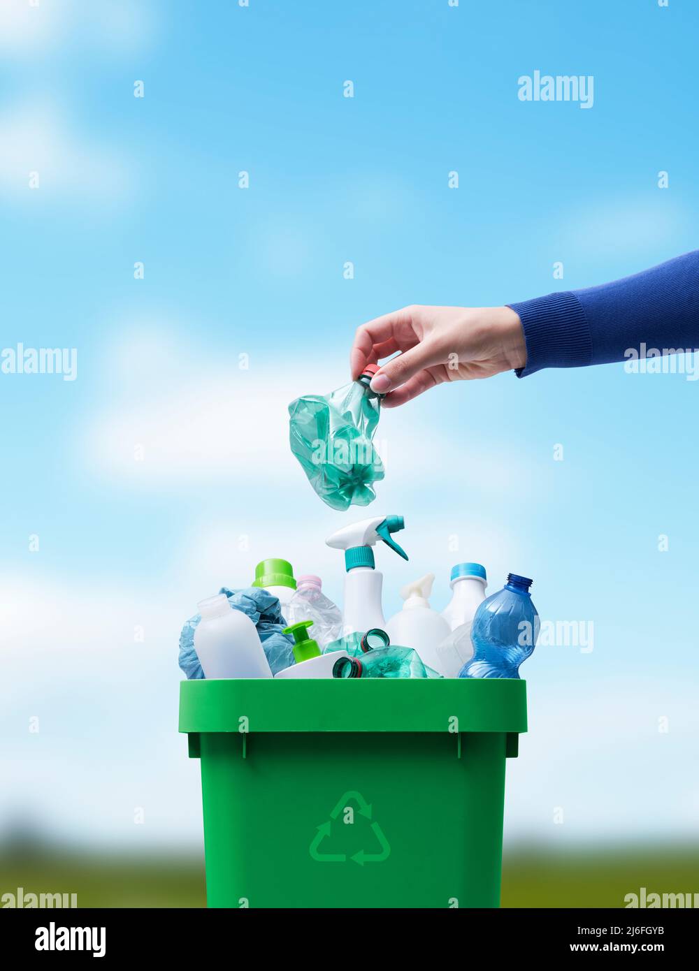 Woman putting a plastic bottle in a full recycling bin, separate waste