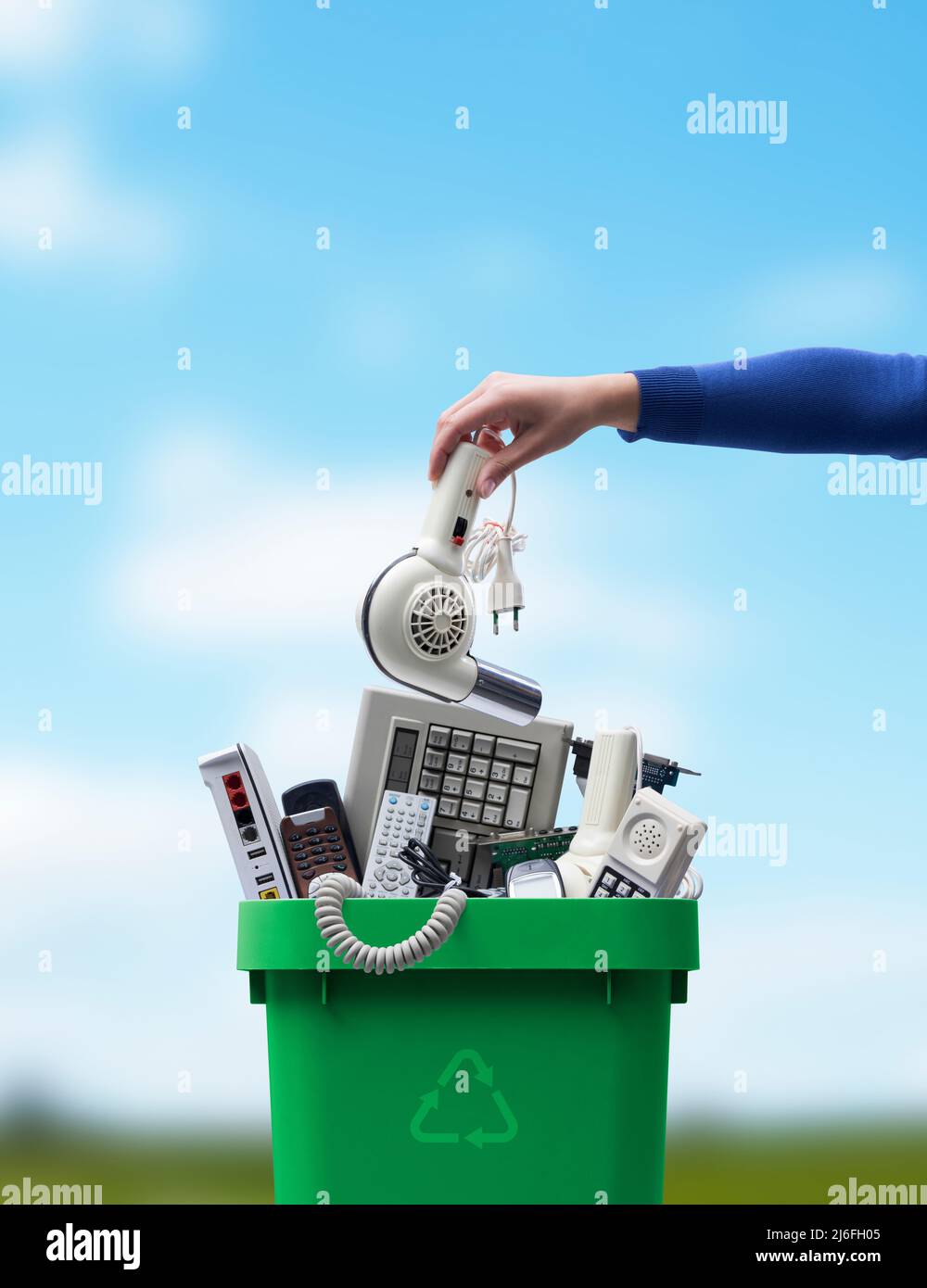 Woman putting an old broken appliance in the trash bin, ewaste and