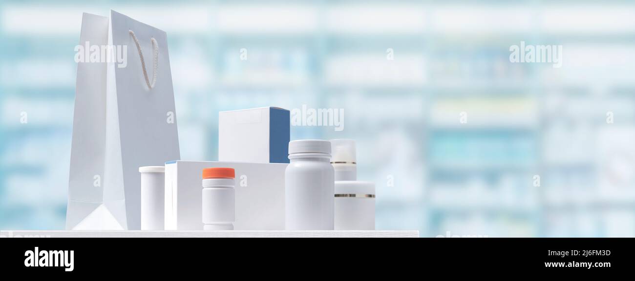 Medicines and cosmetics on the pharmacy counter, store shelves in the background Stock Photo