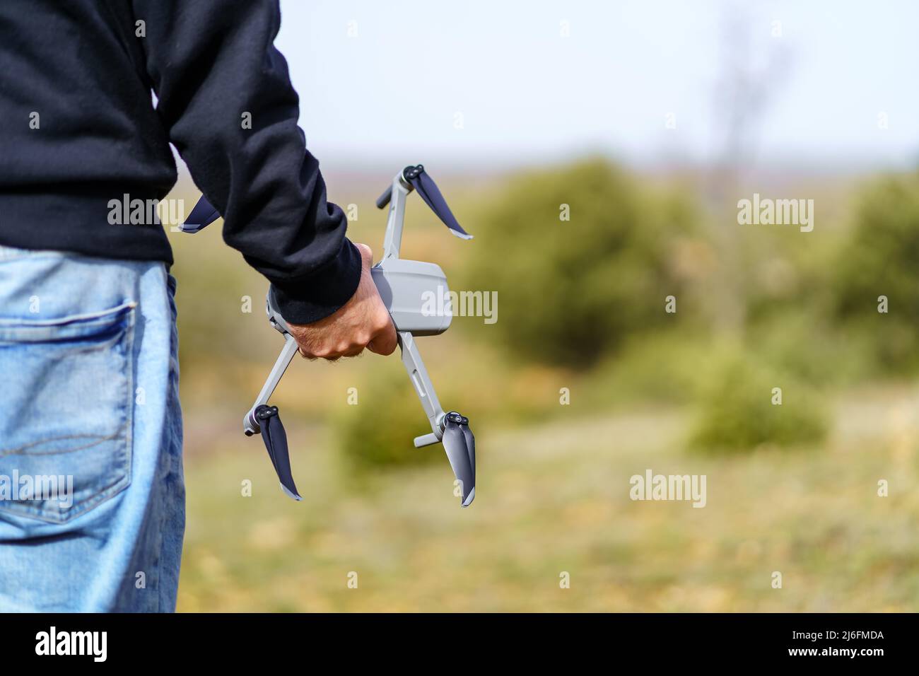 Man holding a drone with his hand before flying it through the sky. Stock Photo