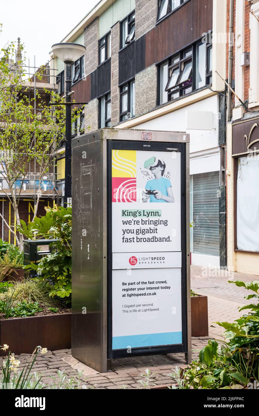 An advertisement on an old public telephone kiosk offers gigabit fast broadband in King's Lynn, Norfolk, from Lightspeed Broadband. Stock Photo