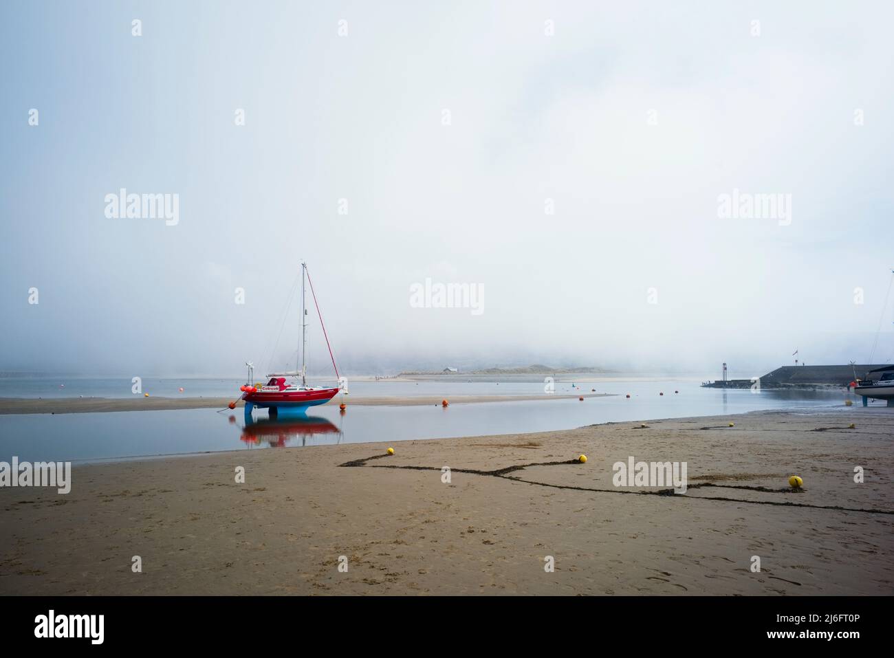 Barmouth harbour at very low tide with a sea mist Stock Photo