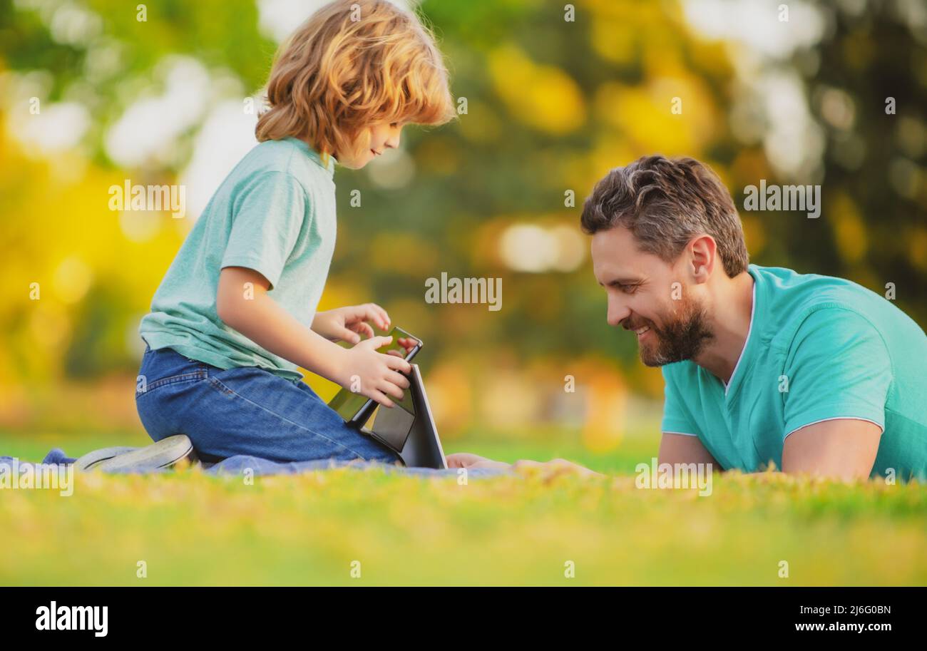 Happy father using laptop relax with schooler son holding laptop have ...