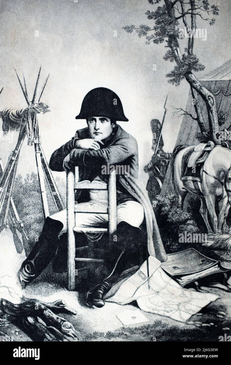 Illustration of Napoleon Bonaparte sitting in camp at Austerlitz (1805). An Imperial Guardsman stands sentry in the background. From a postcard c. early 1900s Stock Photo
