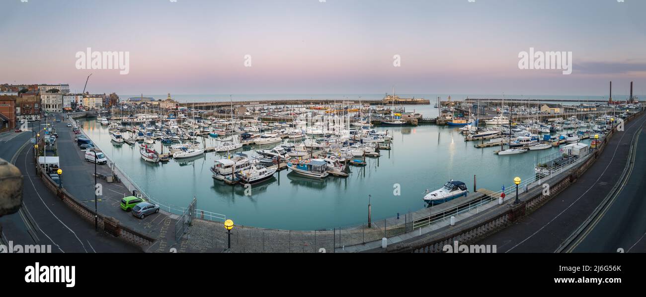 Ramsgate, UK - April 20 2022 Panoramic image of the historic Royal Harbour at dusk. The inner and outer basin of the harbour, plus the harbour wall an Stock Photo