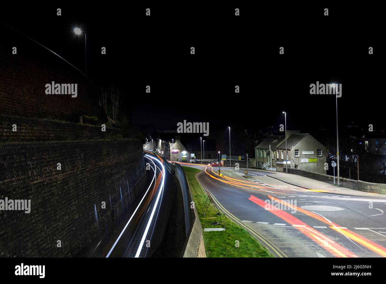 Light trails on the road and railway line in Galashiels town centre, at night, Scottish Borders, UK Stock Photo