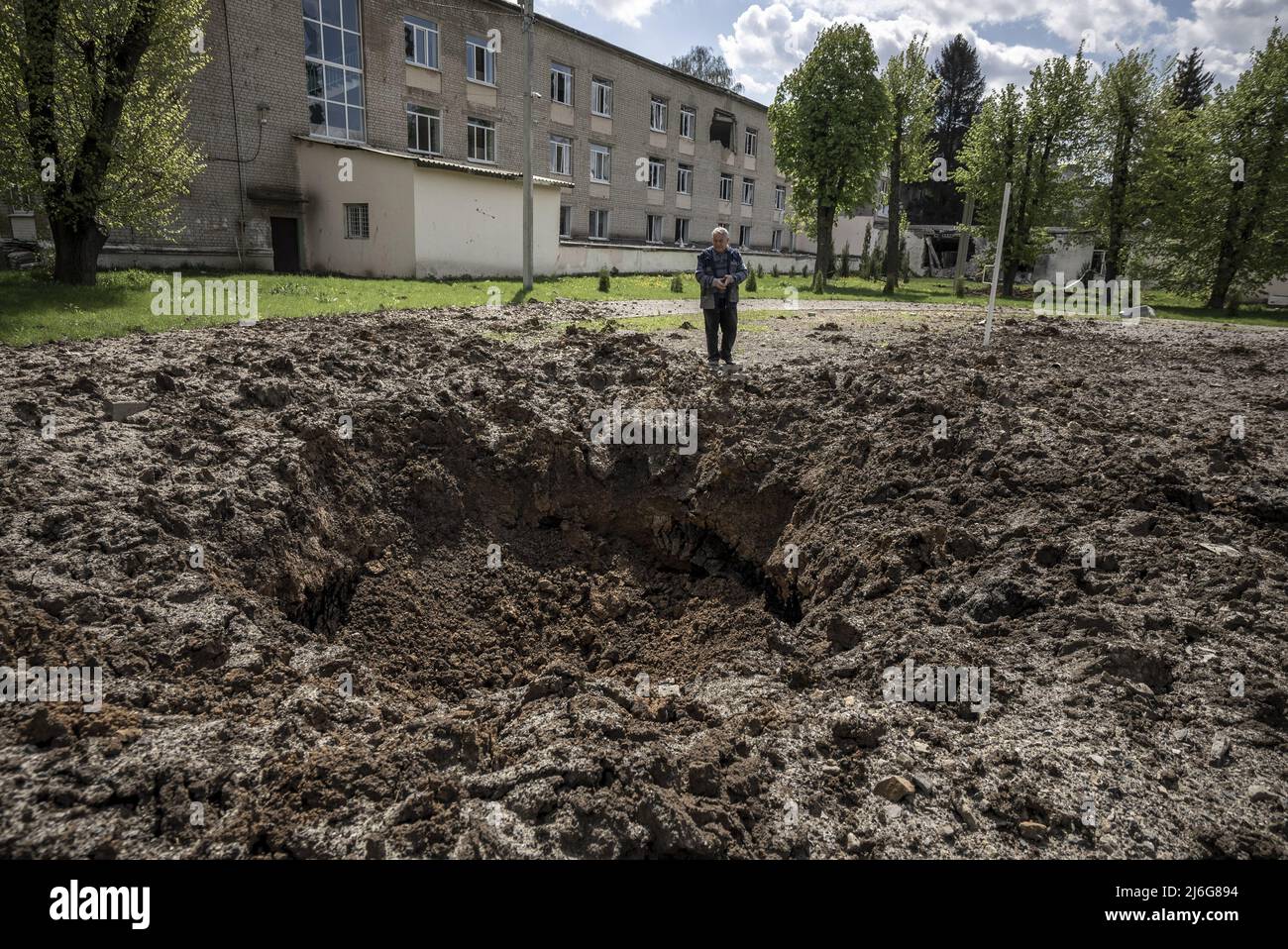 Alexander Grigorevich Gryanik, 67, Principle of No. 62 School, stands next to a crater left by an artillery round fired from the Russians 10 kilometers away outside of Kharkiv, Ukraine, May 1, 2022. At the peak of the shelling in the elementary school, about 120 people were hiding in the basement. Today it's 30. Photo by Ken Cedeno/UPI . Credit: UPI/Alamy Live News Stock Photo