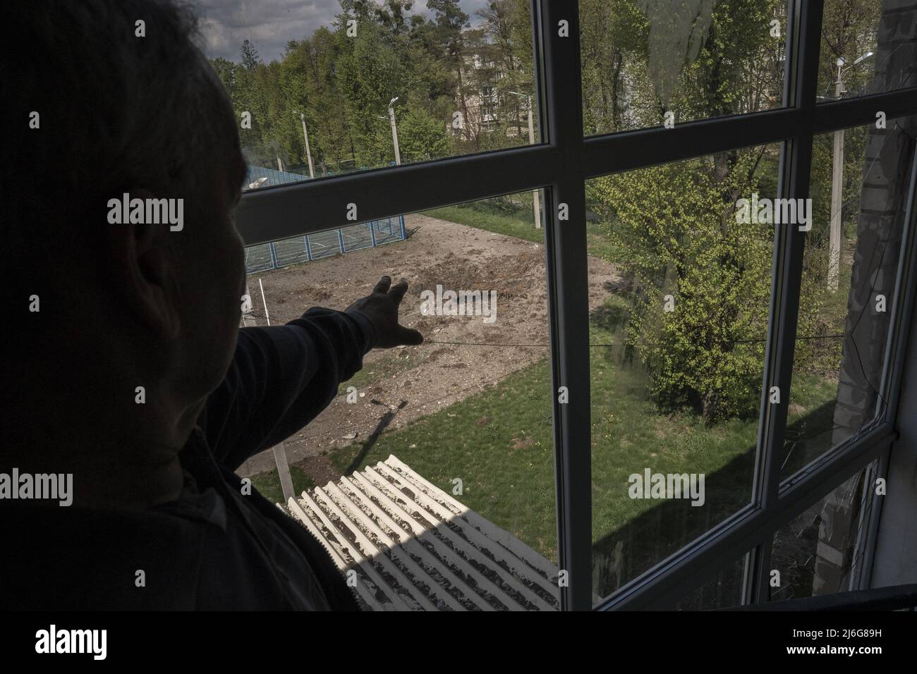 Alexander Grigorevich Gryanik, 67, Principle of No. 62 School, points to a crater left by an artillery round fired from the Russians 10 kilometers away outside of Kharkiv, Ukraine, May 1, 2022.  Photo by Ken Cedeno/UPI . Credit: UPI/Alamy Live News Stock Photo