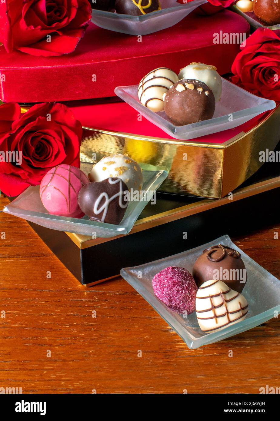 fancy chocolates in mini candy dishes are stacked on candy boxes with