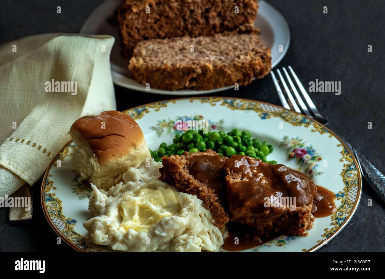 meatloaf with savory brown gravy, peas, roll and mashed potatoes Stock