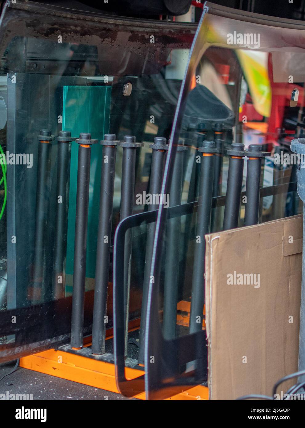 Replacement windshields sit in a rack in a delivery truck, ready to be installed in vehicles Stock Photo