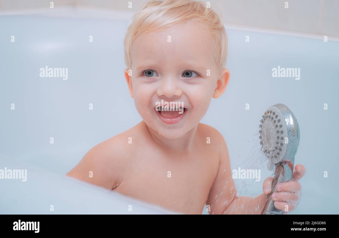 Child bubble bath. Pretty smiling little boy taking a bath with soap