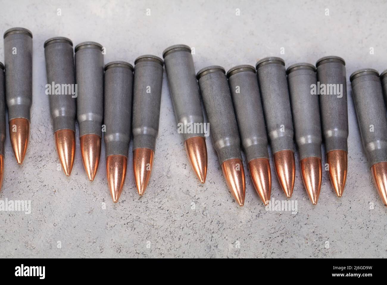 kalashnikov ak gun 7,62 mm bullets on grey concrete surface background Stock Photo