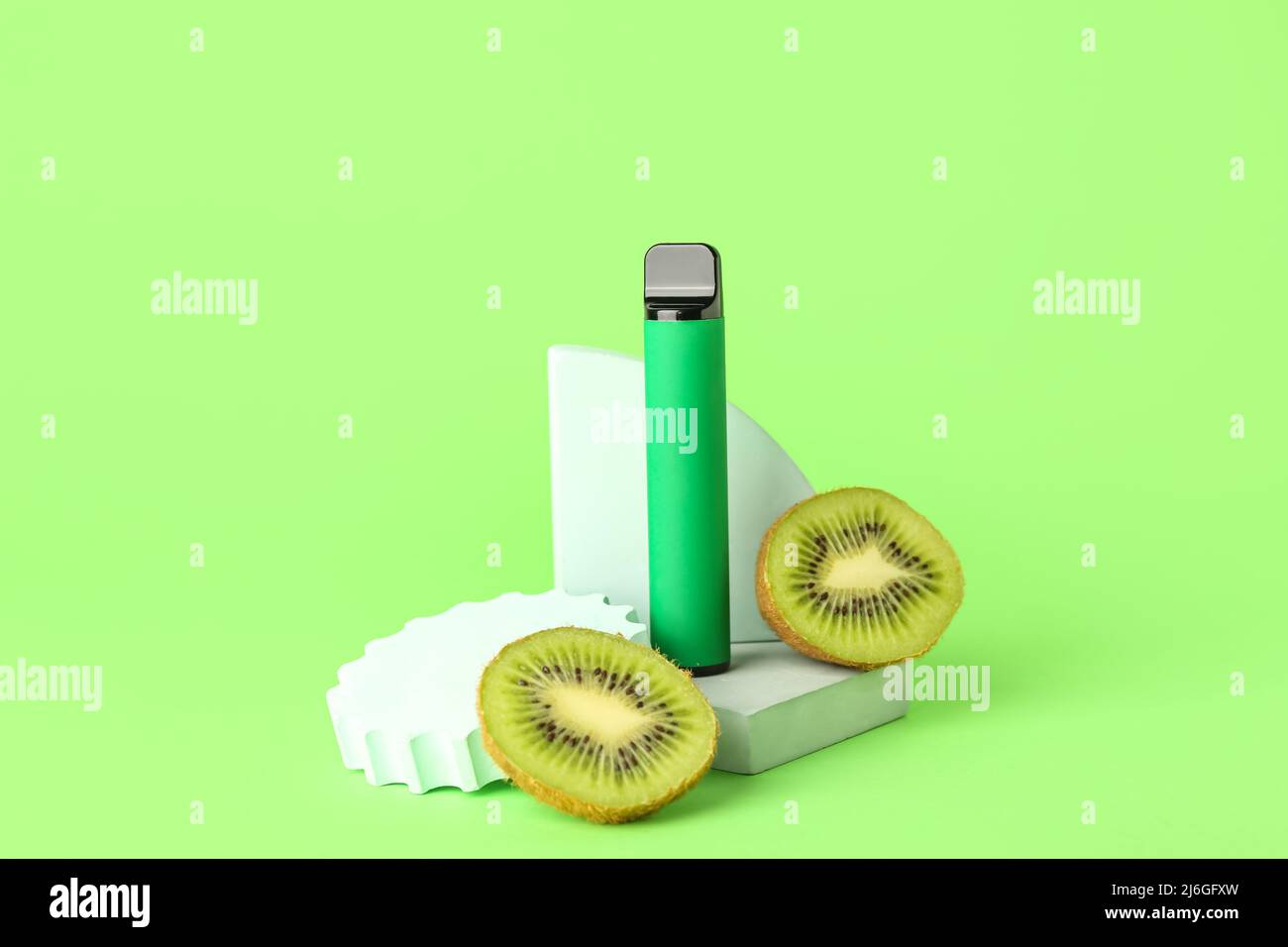 Disposable electronic cigarette and kiwi on green background Stock Photo