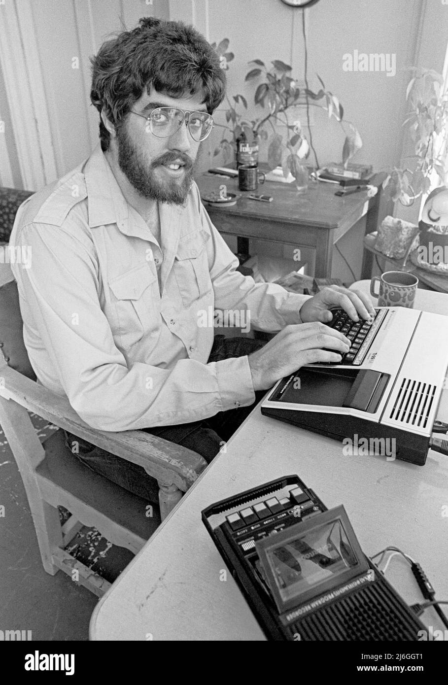 Mike Moore creating games on his TI 99-4a computer based on battles in the Civil War in San Francisco, saving his game data on a tape recorder, He also created a modem dial up Bulletin Board game called Draken's Keep. September 1983 Stock Photo