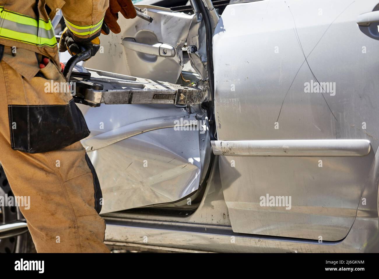 Fire Fighter using the jaws of life to remove the roof of a car in a demonstration Stock Photo