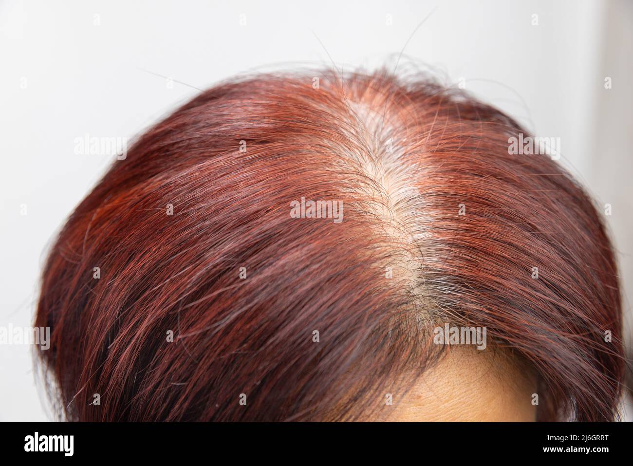 Middle aged asian woman concern about gray hair in menopause Stock